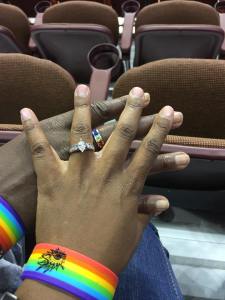 Holding hands with rings and rainbow wristbands